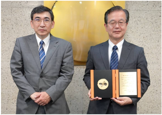 日座操從日本橡膠協(xié)會主席斎藤拓(東京農(nóng)業(yè)和技術(shù)大學(xué)教授)(左)手中接過表彰獎牌 日座操從日本橡膠協(xié)會主席斎藤拓(東京農(nóng)業(yè)和技術(shù)大學(xué)教授)(左)手中接過表彰獎牌
